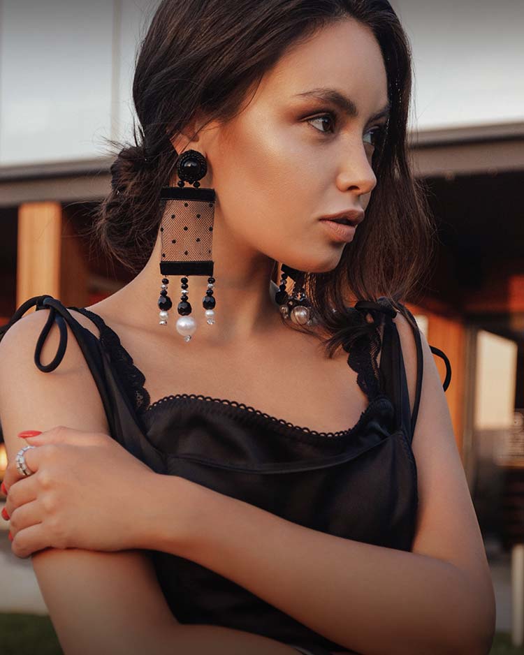 Beautiful model with contoured makeup and wearing large fashion earrings