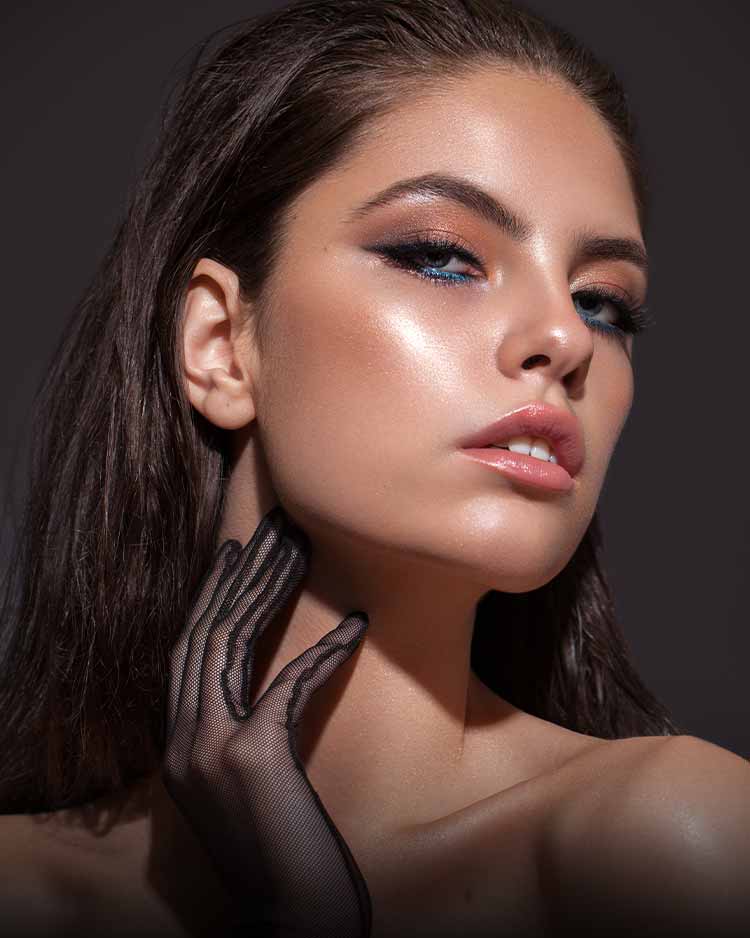Beautiful model with brown, orange and blue eyeshadow and a bronzed glowing complexion
