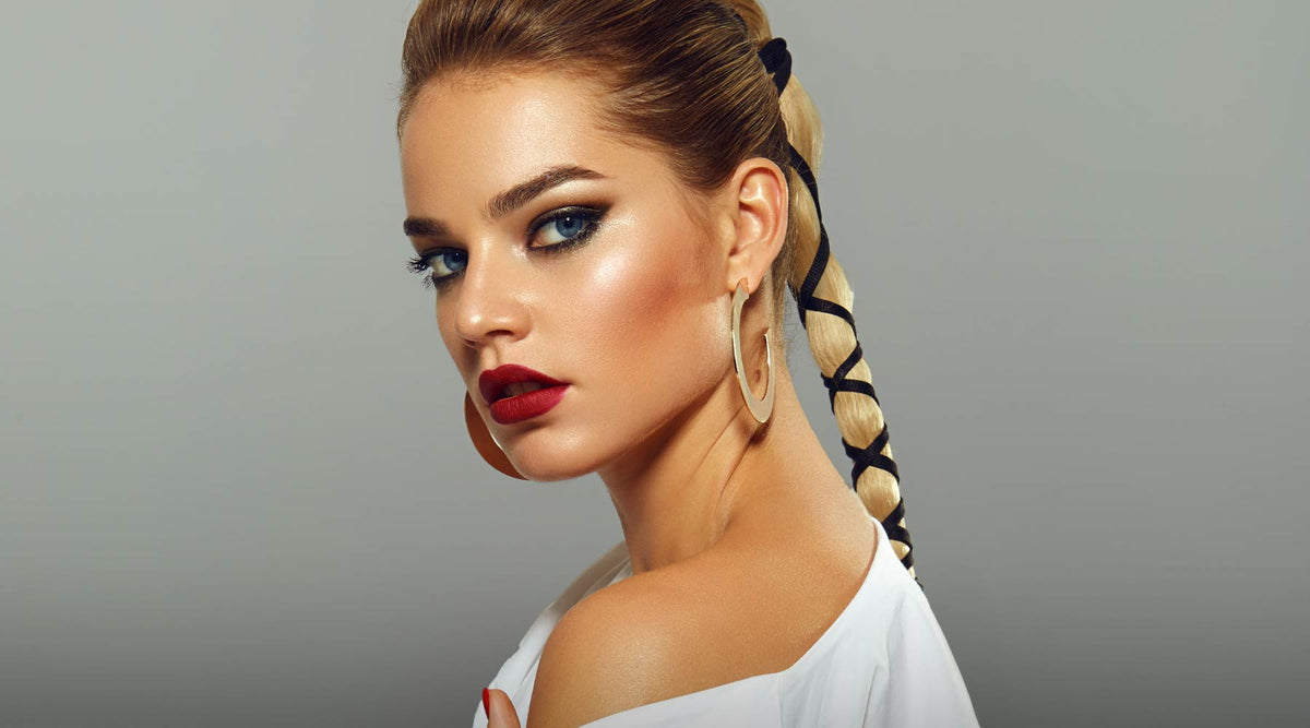 Beautiful model with blonde hair in a plait with smokey eye makeup and red lipstick.