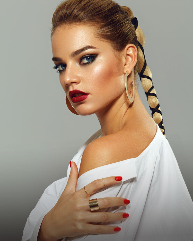 Beautiful model with blonde hair in a plait with smokey eye makeup and red lipstick.