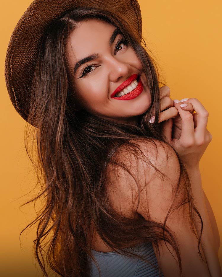 Beautiful model with bright red lips on a vibrant yellow background