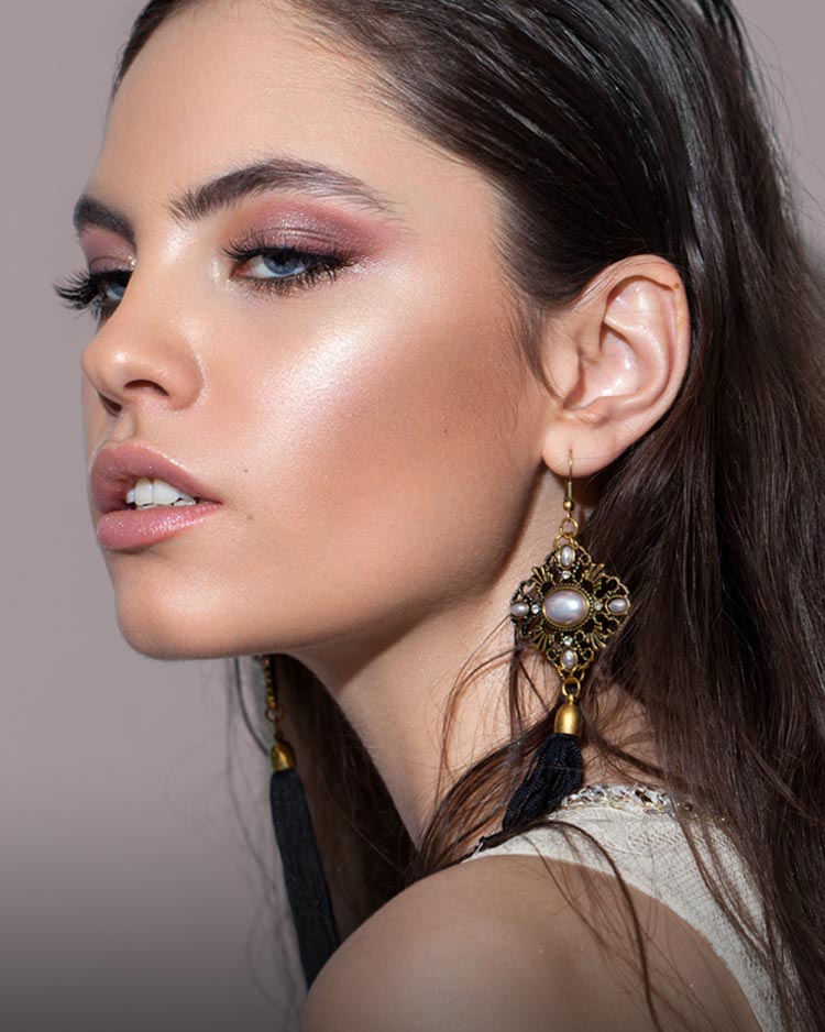 Beautiful model with soft smokey eyeshadow, glowing makeup, nude lipstick and subtle false eyelashes.