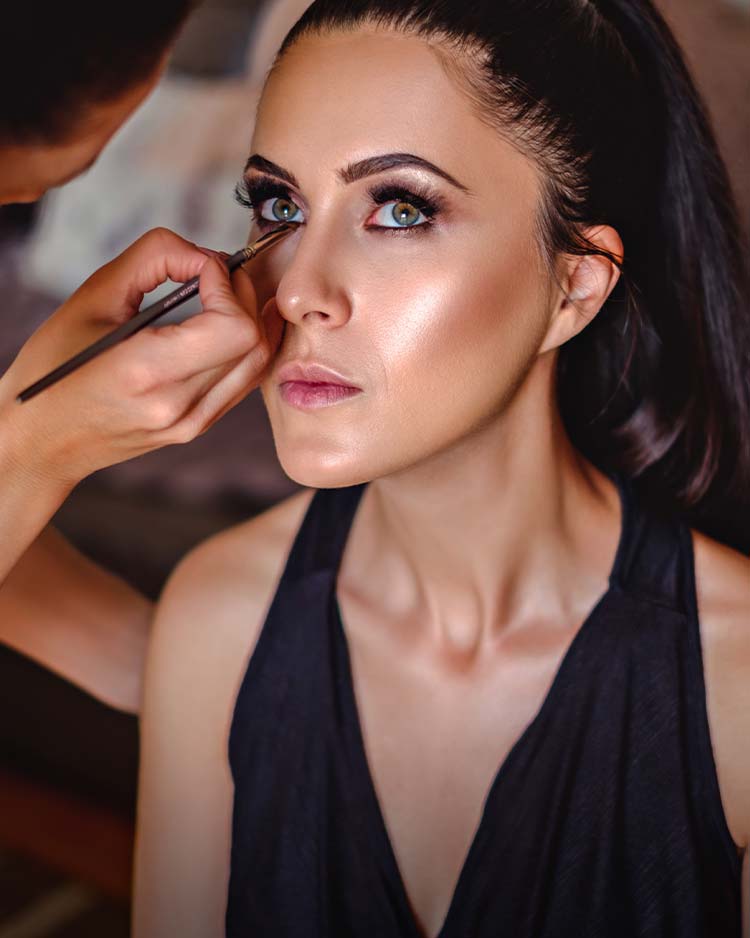 Makeup artist applying eyeliner to model with London Copyright makeup brush.