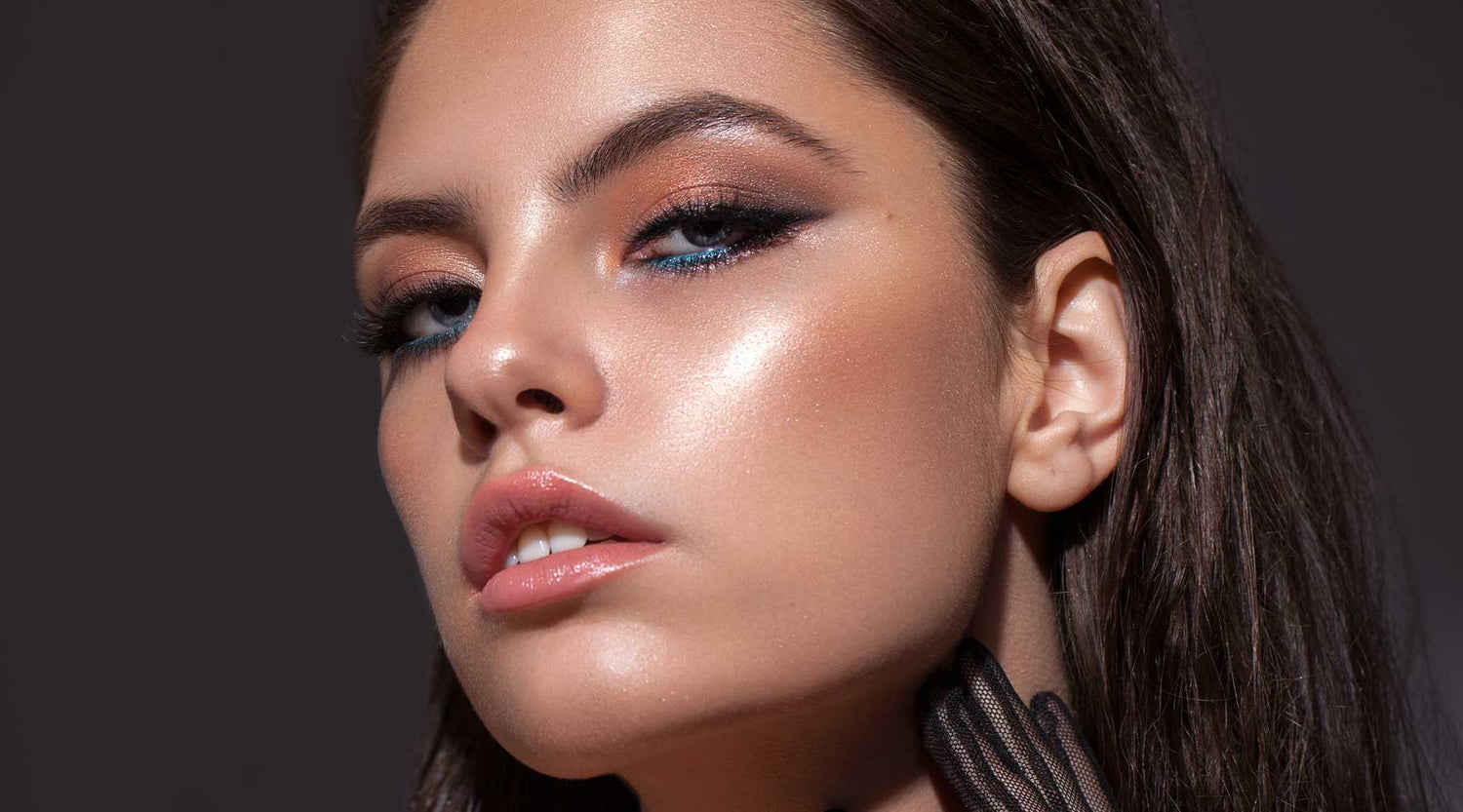 Beautiful model with smokey eyeshadow and blue lower lash line with glowing complexion.