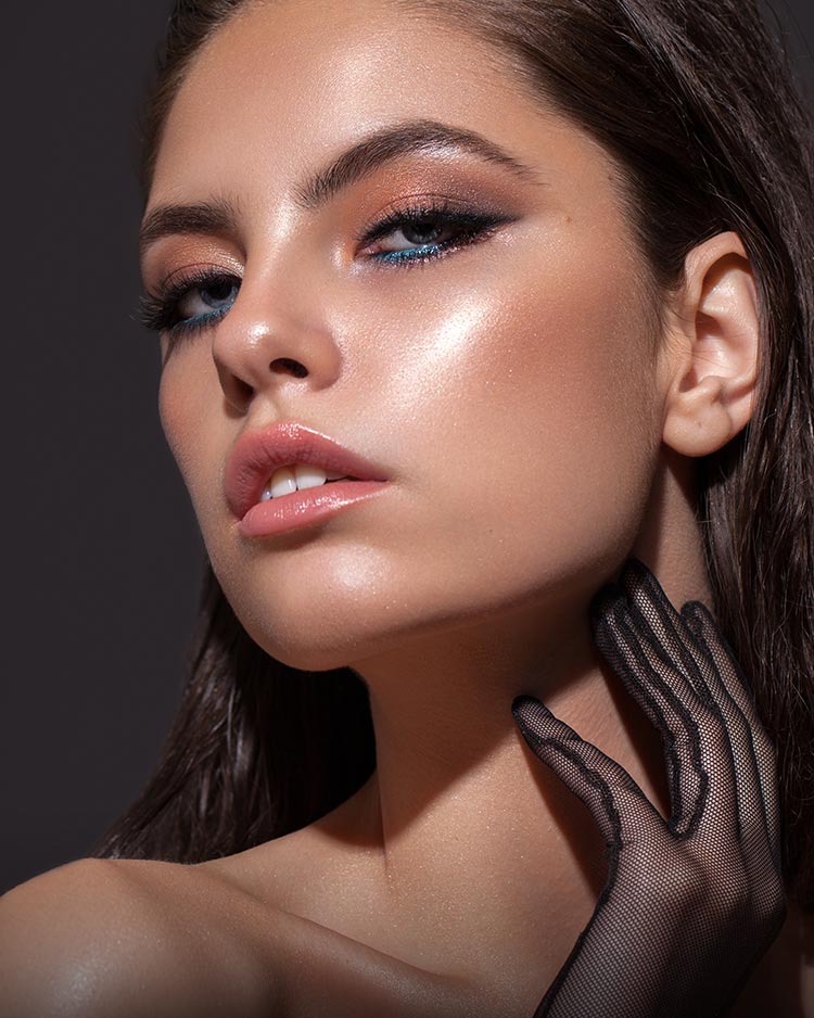 Beautiful model with smokey eyeshadow and blue lower lash line with glowing complexion.
