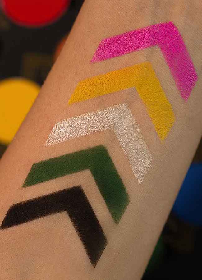 Playhouse Eyeshadow Palette arm swatch showing pink, yellow, white, green and black shades.